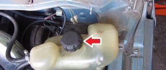 The arrow indicates the cap of the cooling expansion tank.